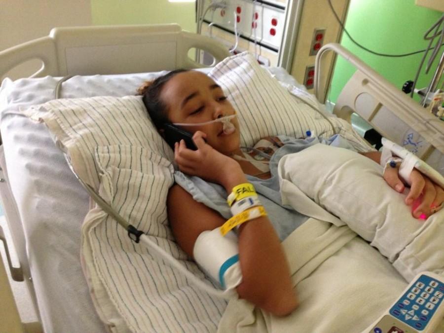 Rodriguez sets in her bed, talking on her phone, after her surgery to fix her scoliosis.
