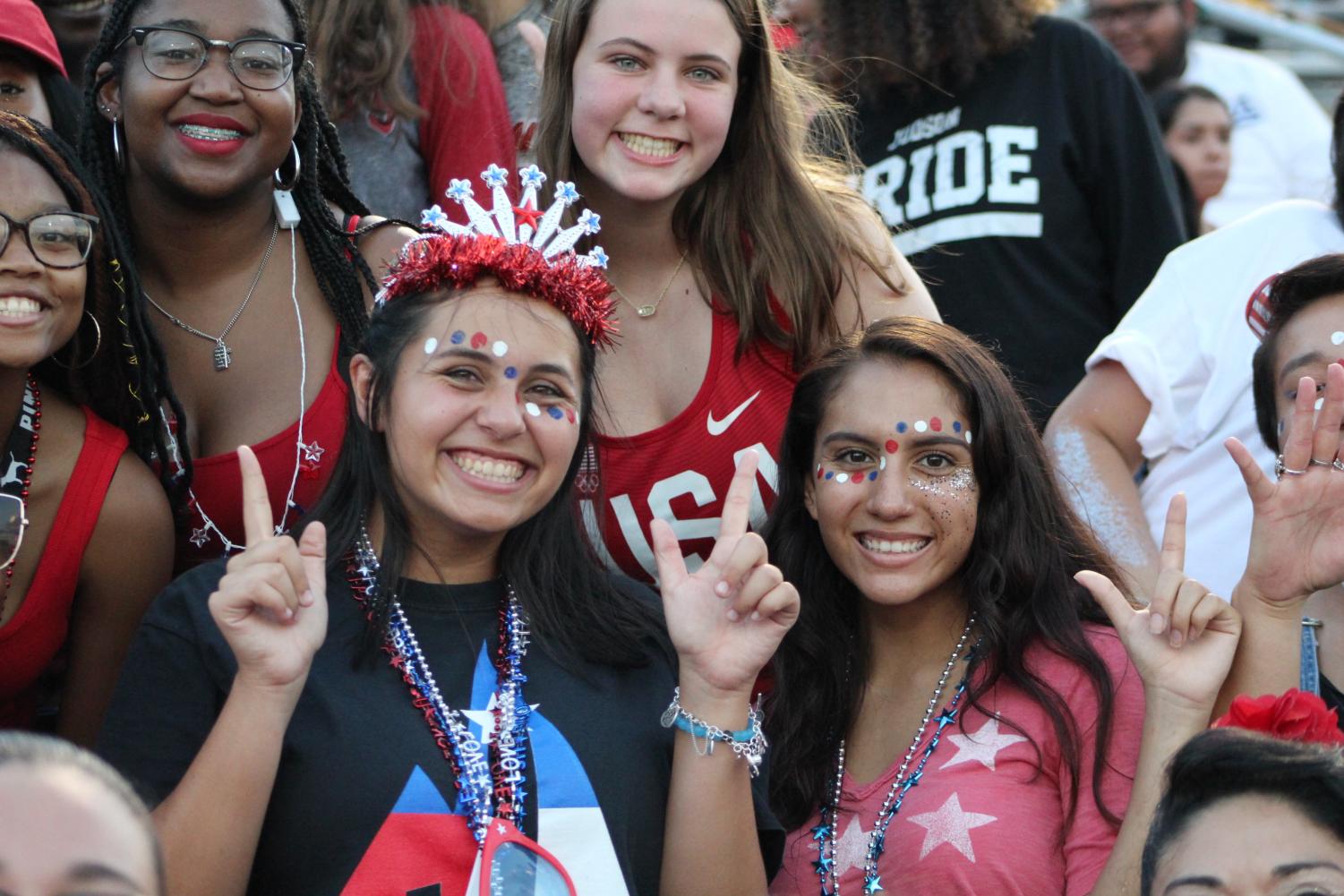 Junior Madalynn Lambert, in full American gear, cheers on her Rockets during a football game. Lambert is also an editor of the newspaper.