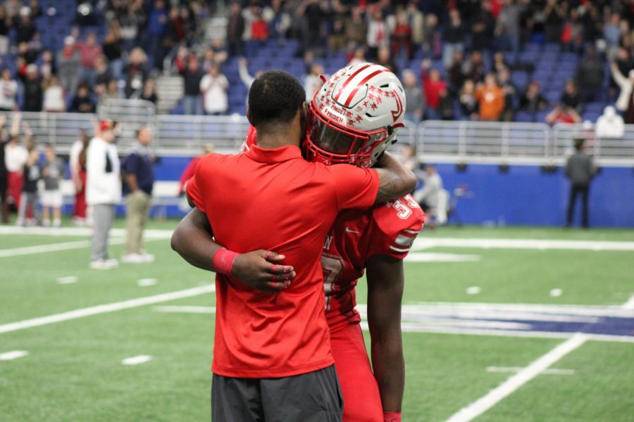 Senior Rashad Wisdom shares an emotional moment with a alumni. The Rockets fell to the Lake Travis Cavaliers 38-21 to end their season.