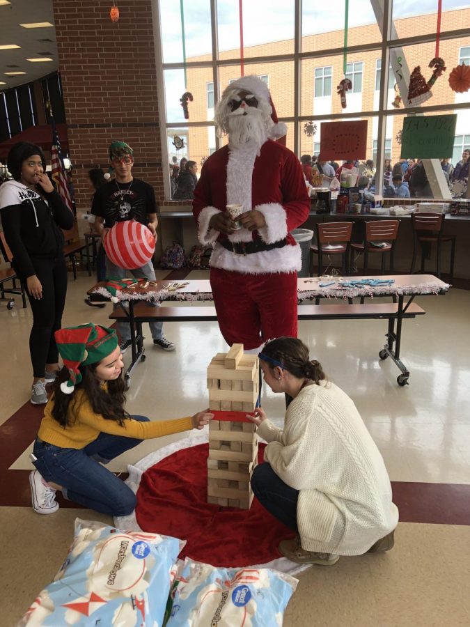 The+junior+class+officers+and+%E2%80%9CSanta%E2%80%9D+play+Jenga+at+the+Santa+Workshop+in+the+Cafeteria+during+lunch.+The+Santa+Workshop+worked+as+a+fundraiser+for+project+graduation.