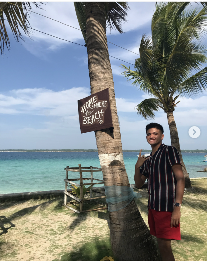 Senior JonPatrick poses in front of a palm tree at one of the few islands he visited back home during the summer. JohnPatrick moved from the Philippines to the states when he was younger and goes back during summer to see family and reconnect. 