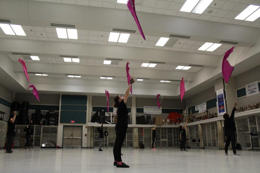 Varsity color guard practices tosses together in class. The varsity team competed in the winter season the show “Aretha Franklin: Queen Of Soul.” 
