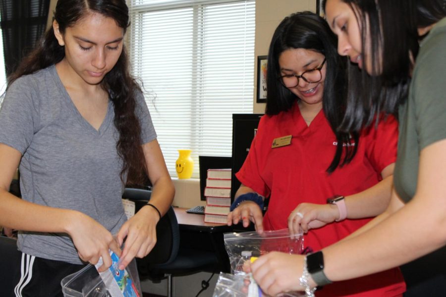 Senior Amorette Rodriguez, senior April Jacobo Gonzalez, and junior Maddie Lambert put different necessities into bags for those in need. This is the Student Councils first year collecting Blessing Bags. 