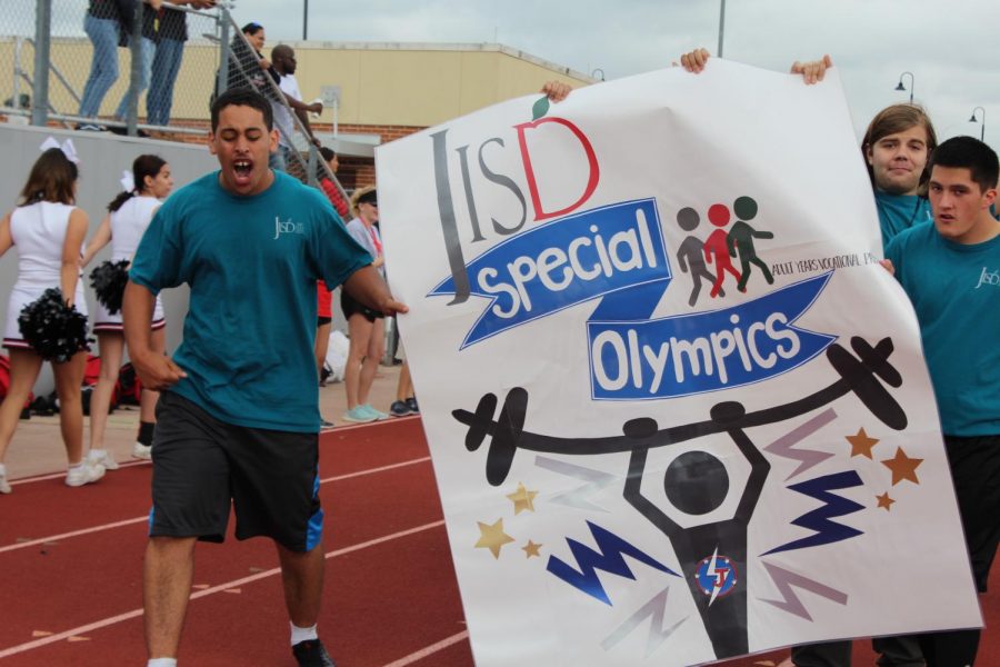 Students+from+the+adult+special+education+program+run+through+the+opening+ceremonies+with+the+JISD+Special+Olympics+banner.