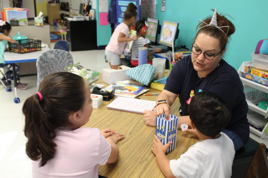 Olympia Elementary School pre-k teacher Mrs. Amy Guel sounds out letters with two of her students. Currently, the pre-k programs are on a half day schedule.