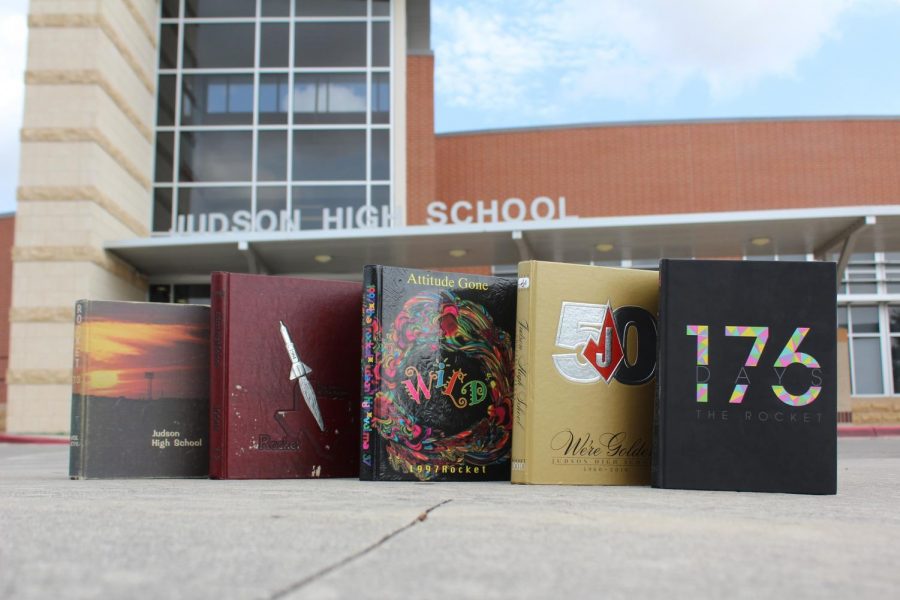 Yearbooks from 79, 84, 97, 2010, and 2019 are on display in front of the school.
