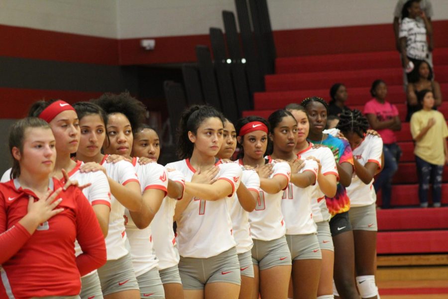 Players+line+up+for+the+national+anthem+before+their+pre-district+game.