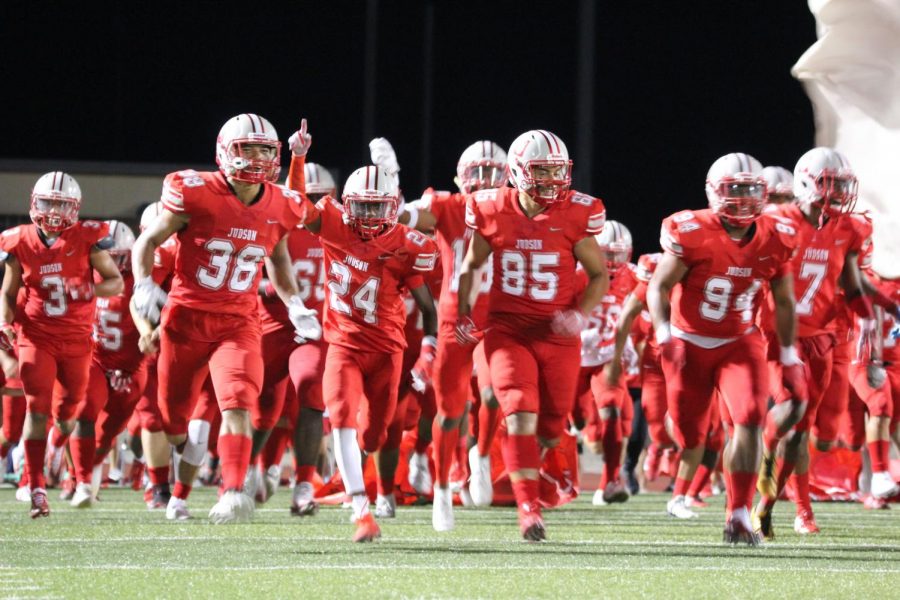 The football players run through the traditional break through at the annual Hammer Bowl game. The Rockets won, 52-14.