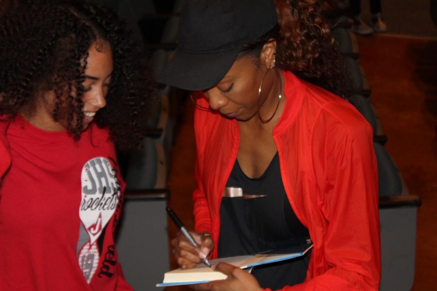 Olympic champion Sanya Richards-Ross signs copies of her book, Right on Track: Run, Race, Believe for members of the girls track teams.