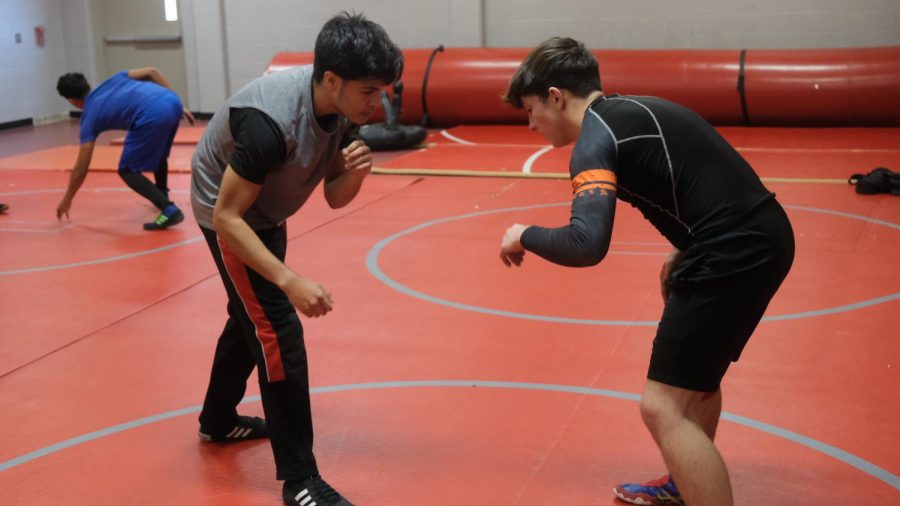 Senior Manuel Martinez and junior Jonathyn Kidd practice takedowns during their practice. The wrestling season, usually considered a winter sport, has been pushed back into the spring.