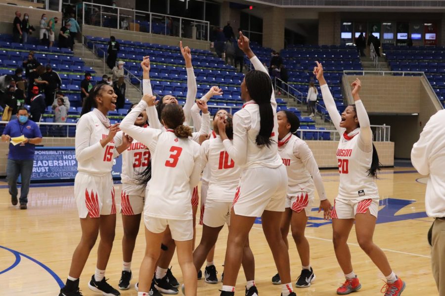 The girls basketball team celebrates in the middle of the court at Northside Athletics Gym. The girls will advance to the next round of the playoffs.