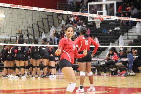 Junior Gaia Pescosolido smiles in between sets. When she was asked to pose, she made her signature smile and thumbs up during the game.