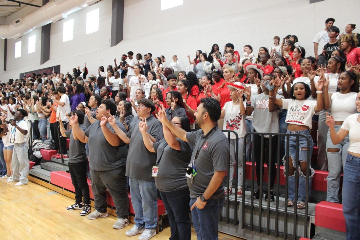 Concluding the pep rally for the Sept. 27 football game against East Central, students and staff sing the alma mater while honoring the tradition of showing the Judson "Diamond J" hand sign.