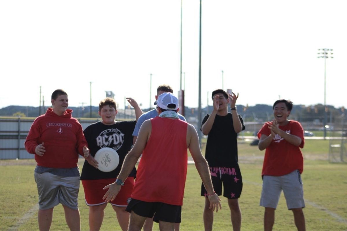 Hisquierdo hypes up student athletes before an ultimate frisbee practice match.