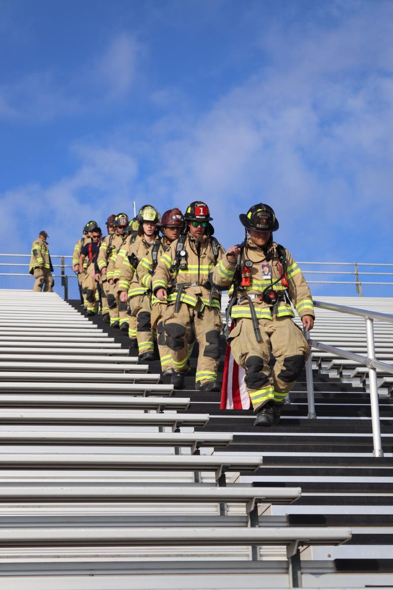 Converse firefighters lead the walk down the bleachers during the 9-11 Remembrance event at D. W. Rutledge Stadium.